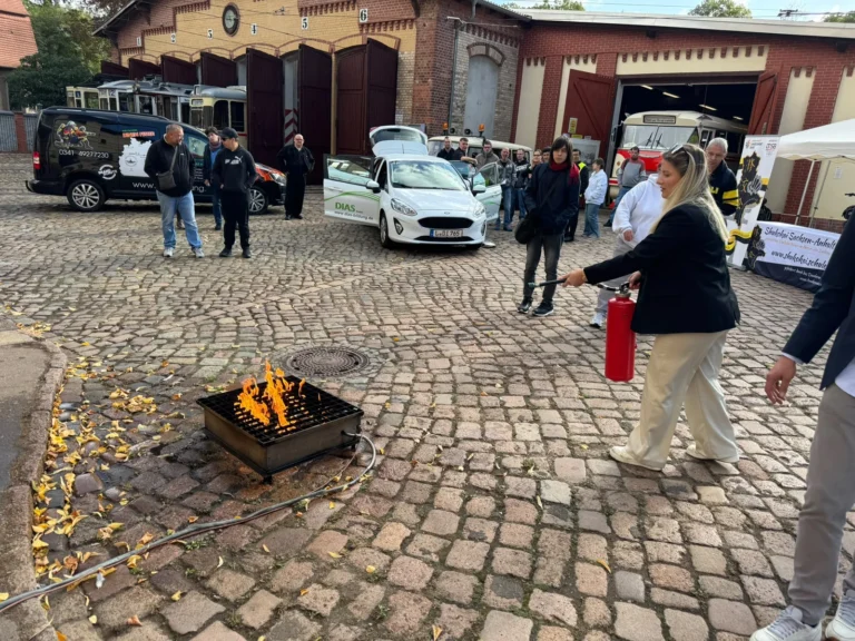Teilnehmerin übt den Einsatz eines Feuerlöschers beim Tag der offenen Tür von DIAS Bildung in Halle.