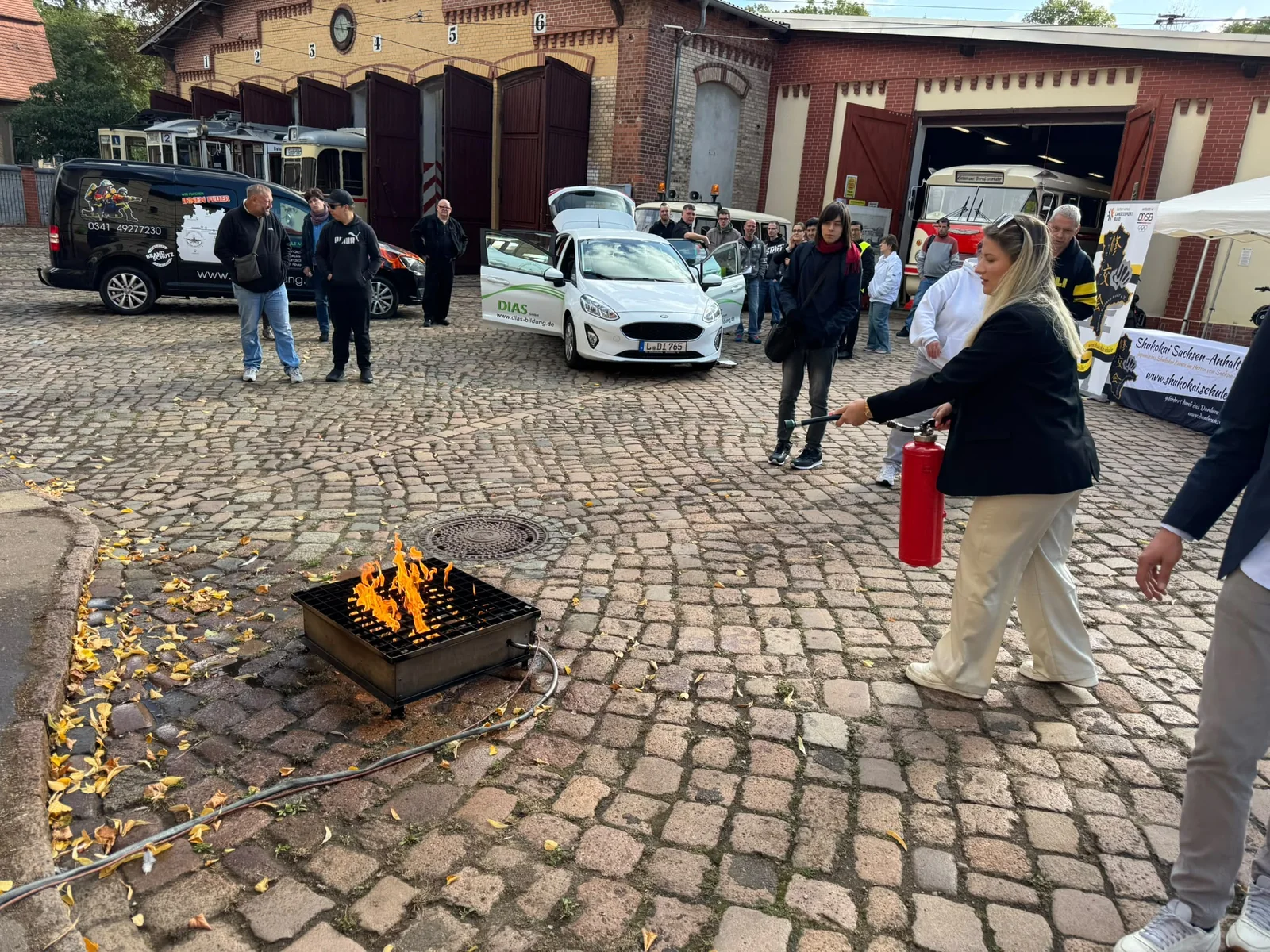 Teilnehmerin übt den Einsatz eines Feuerlöschers beim Tag der offenen Tür von DIAS Bildung in Halle.